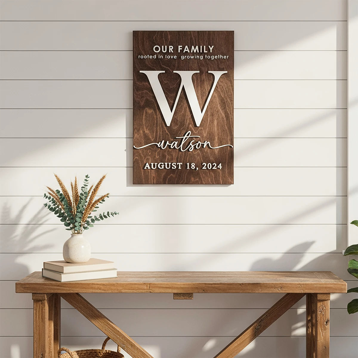Wooden wall art with 'Our Family' and 'Watson' text on a white wooden panel background.